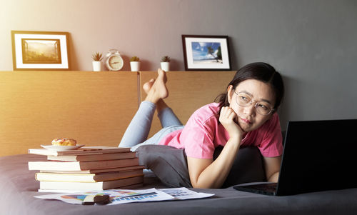 Full length of woman sitting on table at home