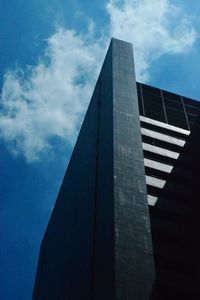 Low angle view of skyscraper against cloudy sky