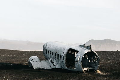 Abandoned airplane on land against sky