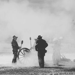 Men working on field against sky