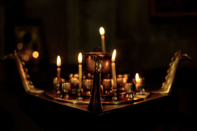 Burning candles by containers on table at church