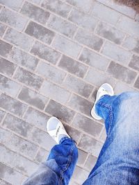 Low section of man standing on tiled floor