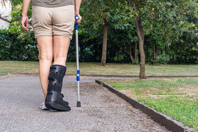 Low section of man walking on road