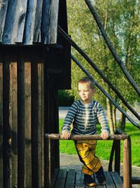 Boy standing on wooden house at park