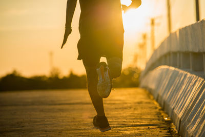 Low section of man running on road