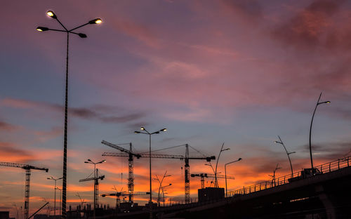 Low angle view of silhouette street lights against sky during sunset