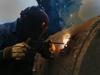 Close-up of worker welding metal at dusk