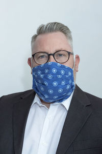 Portrait of man wearing mask against white background