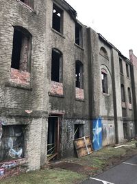 Old building by street against sky