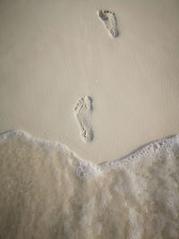 High angle view of footprints on sand at beach