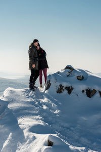 Man standing on snowcapped mountain against sky