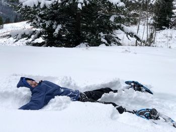 Man lying on snow covered land