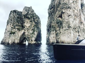 Panoramic view of rock formation in sea against sky