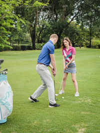 Full length of couple playing golf 