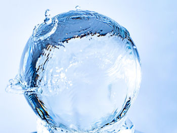 Close-up of glass of water against blue background