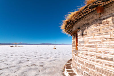 Scenic view of beach against clear blue sky