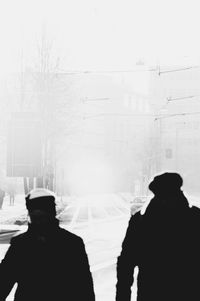 Rear view of silhouette people in city