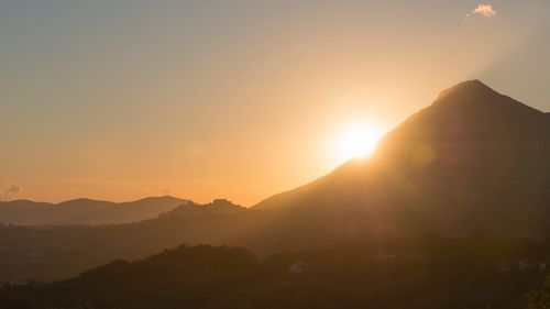 Scenic view of silhouette mountains against sky at sunset