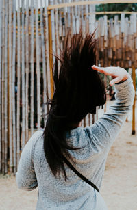 Rear view of woman with tousled hair standing outdoors