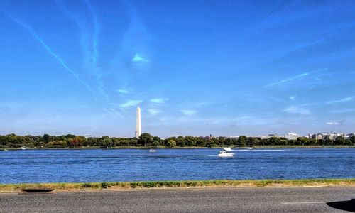 Sailboats in lake against blue sky