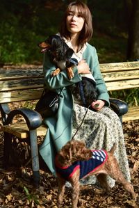 Portrait of woman sitting outdoors with dogs