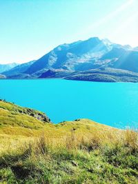 Scenic view of lake and mountains against blue sky