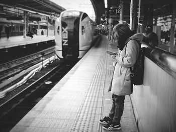Woman standing on railroad track