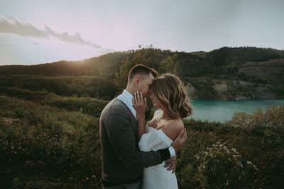Couple standing on woman against sky