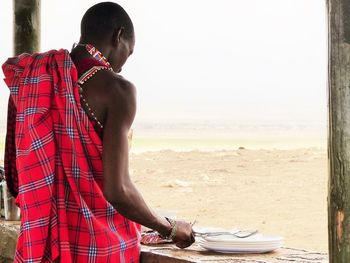 Young man standing on land against sky