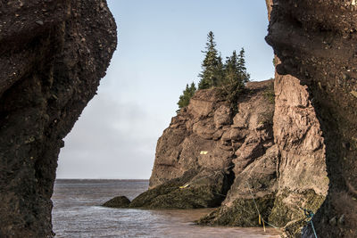 Rock formations by sea against sky