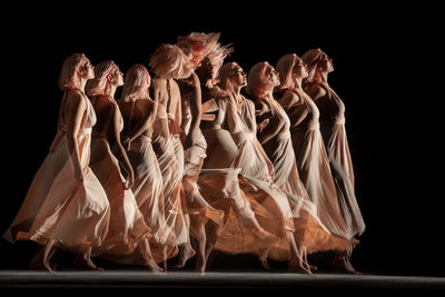 Young woman in front of black background. long exposure with stroboscopic flash