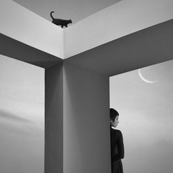 Woman standing by built structure against sky