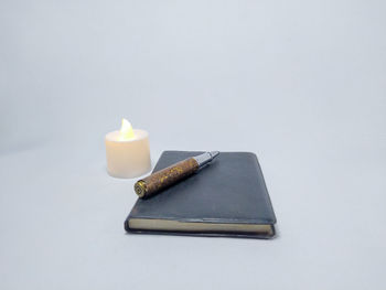 High angle view of candles on table against white background