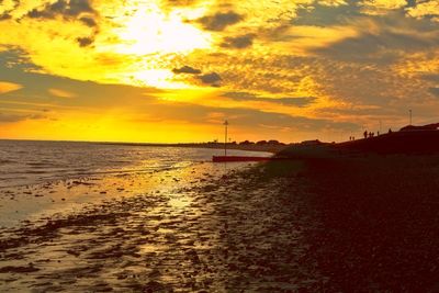 Scenic view of sea against cloudy sky at sunset