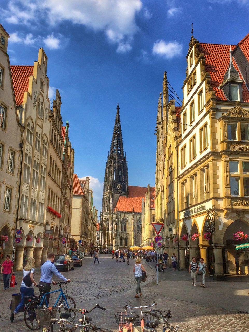 building exterior, architecture, built structure, street, city, large group of people, sky, city life, person, men, incidental people, place of worship, residential building, old town, religion, cobblestone, city street, travel destinations, building