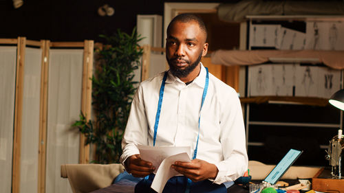 Portrait of young man standing in office