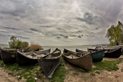 Boats moored at shore against sky
