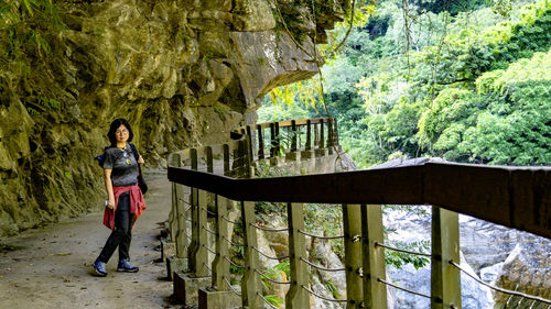 Woman standing on footbridge in cave