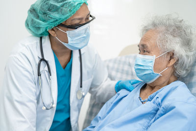 Side view of doctor examining patient at clinic