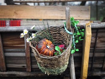Decorative wooden basket filled with pumpkins and flowers