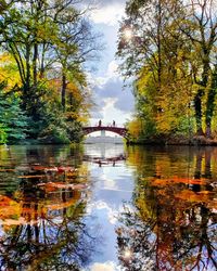Arch bridge over lake against sky during autumn