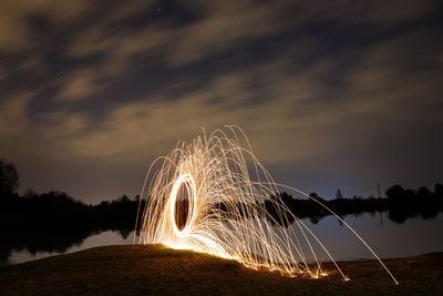 Low angle view of illuminated beach against sky at night