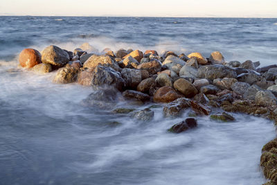 Rocks in sea against sky