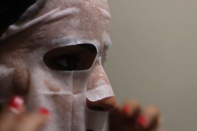 Close-up of woman using facial mask at home