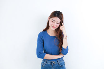 Young woman smiling against white background