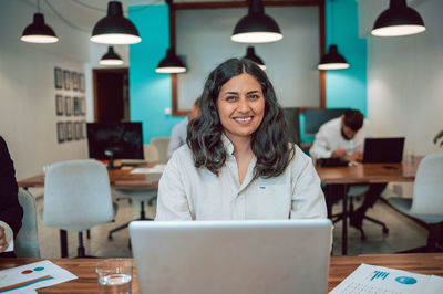 Portrait of young woman using laptop at home