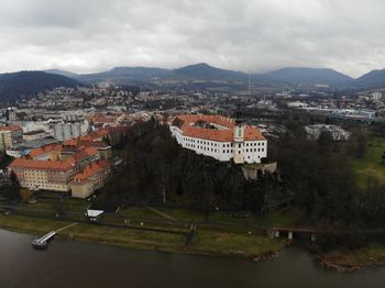 High angle view of townscape by river against sky