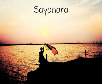 Silhouette people on beach against sky during sunset