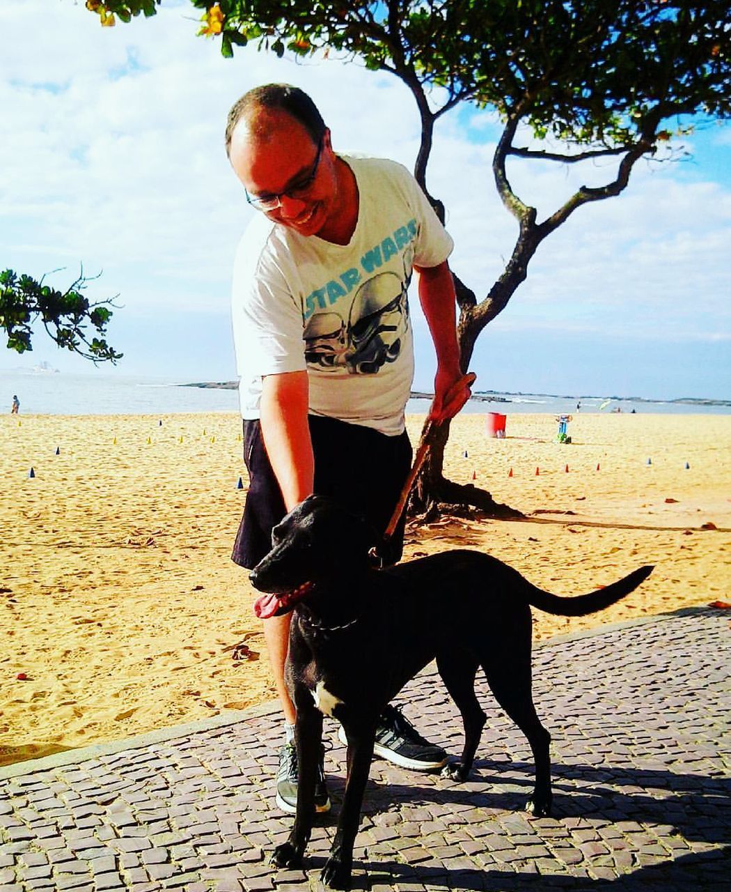 MAN WITH DOG WALKING AT BEACH