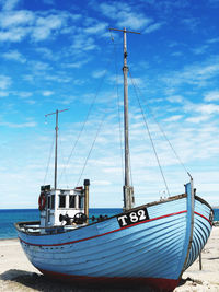 Sailboats moored on sea against sky